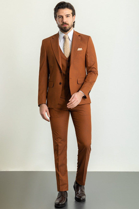 Man wearing a brown suit with a white shirt and tie on a plain background